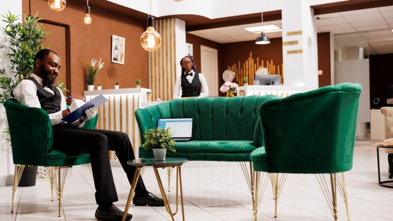 Smiling guy bellboy at hotel lobby